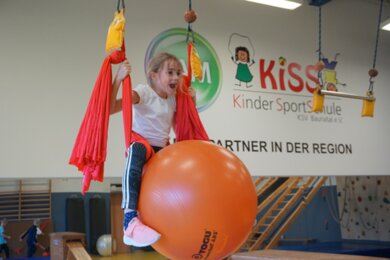 Mädchen in Schaukel mit Ball